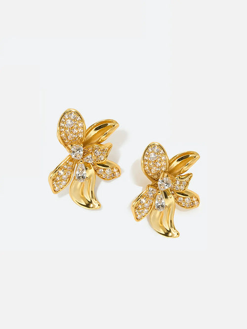 Pair of Tactilery Blossom Stud Earrings on a white background, the oversized gold five-petal orchid flower stud with three fully pavé zircon upper petals, a central prong-set pear-cut zircon, and two smooth polished gold lower petals with ribbed vein texture, with silver post pins