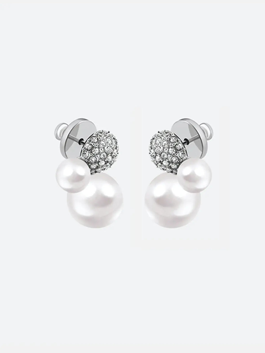 Pair of Tactilery Bubble Stud Earrings in silver shown from the back on a light grey background, the silver disc butterfly backs and silver post pins visible at top, with the large white pearl spheres and small white pearl spheres extending below
