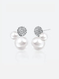 Pair of Tactilery Bubble Stud Earrings in silver on a light grey background, the cluster stud with a fully pavé zircon dome sphere at top, a small white pearl sphere at mid-right, and a large white pearl sphere at bottom, with silver post pins