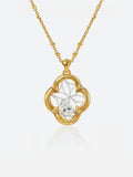 A Tactilery garden dream crabapple window necklace with a four-leaf clover pendant featuring a central clear gemstone, shown on a light gray background with a soft reflection below.