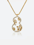A garden dream gourd window necklace featuring a stylized gourd or gourd shape adorned with small gold flowers and clear stones, suspended from a delicate gold chain against a light gray background.