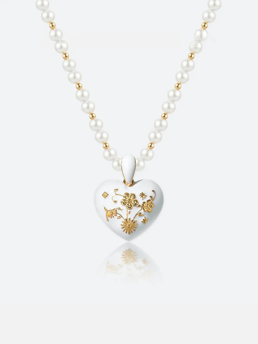 A Tactilery garden floral pearl necklace with a white heart-shaped pendant featuring gold floral engravings, displayed on a clean white background with a soft reflection.
