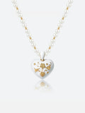 A Tactilery garden floral pearl necklace with a white heart-shaped pendant featuring gold floral engravings, displayed on a clean white background with a soft reflection.