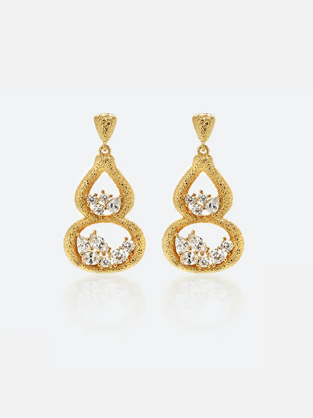 Pair of Tactilery Gourd Texture Stud Earrings in matte brushed gold on a white background, the double-gourd drop stud with heavily sand-textured gold open frame — small teardrop upper chamber and larger oval lower chamber — each chamber holding a prong-set mixed-cut zircon cluster of marquise and round stones, suspended from a textured triangular gold stud top
