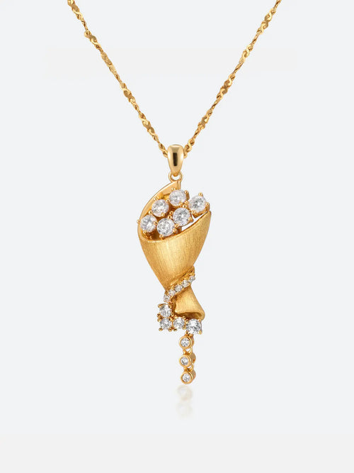 A gold Tactilery bouquet necklace featuring a sculptural lotus flower design adorned with clear gemstones, suspended from a delicate gold chain against a light gray background.