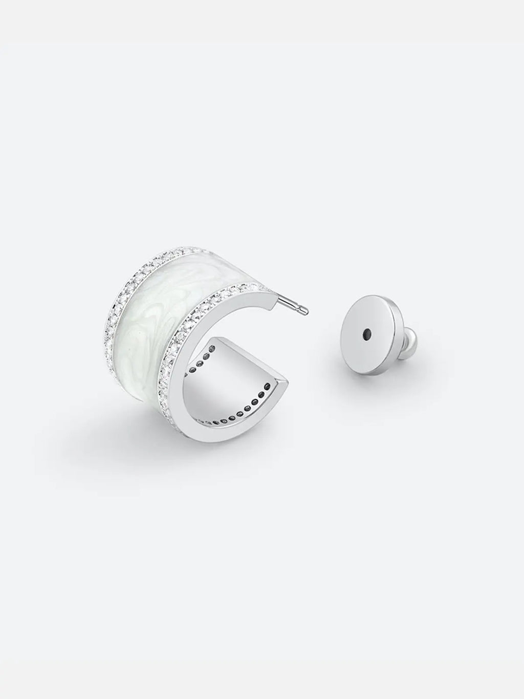 Single Tactilery White Glaze Zircon Hoop Earring displayed at an angle on a light grey background with the silver disc butterfly back removed and placed beside it, showing the silver post pin and the three-dimensional depth of the wide chunky C-hoop with smooth white glaze enamel center panel and two fully pavé zircon rails